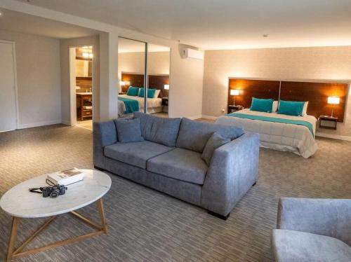 a living room with a couch and a bed at Howard Johnson Plaza & Convention Center Spa La Plata in La Plata