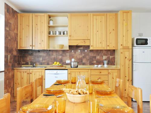 a kitchen with wooden cabinets and a wooden table at Apartment Cesa Fraines-2 by Interhome in Alba di Canazei