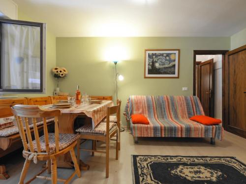 sala de estar con mesa, sillas y cama en Apartment Des Alpes-13 by Interhome, en Canazei
