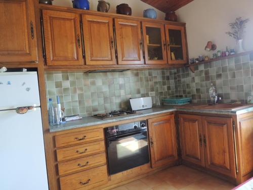 une cuisine avec des armoires en bois et un four à plaques de cuisson dans l'établissement gite le musee, à Villeneuve-Minervois