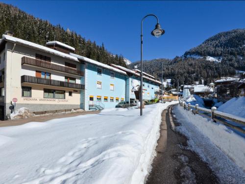 a snow covered street in front of a building at Apartment Apt 3 by Interhome in Canazei