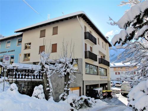 a building in the snow with a tree in front at Apartment Apt 3 by Interhome in Canazei