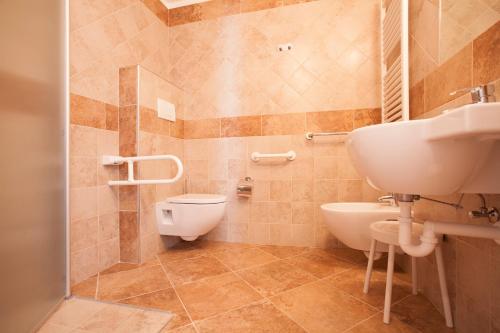 a bathroom with a toilet and a sink at Hotel Vittoria in Folgaria