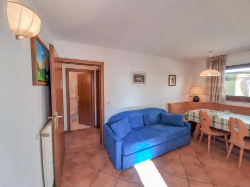 a living room with a blue couch and a table at Apartment Roacia-2 by Interhome in Alba di Canazei