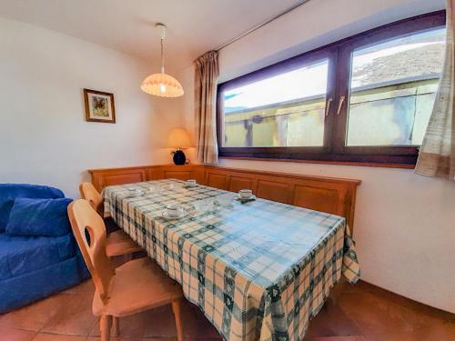 a dining room with a table and a blue couch at Apartment Roacia by Interhome in Alba di Canazei