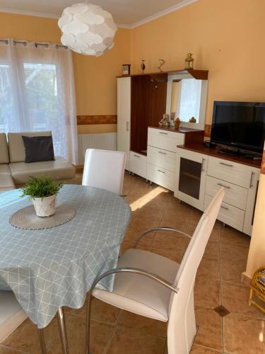 una cucina e un soggiorno con tavolo e sedie di Pesti Apartmanház a Bük