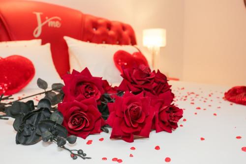 a bunch of red roses on a bed at J'Me Boutique Hotel - Adults only in St Julian's