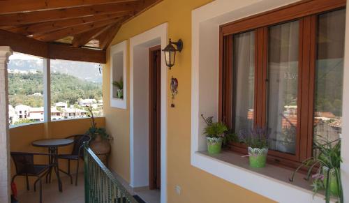 a balcony with a table and chairs and a window at Soureto's House in Liapades