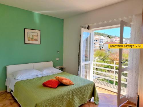 Un dormitorio con una cama con almohadas rojas. en Apartments Garden House, en Podgora