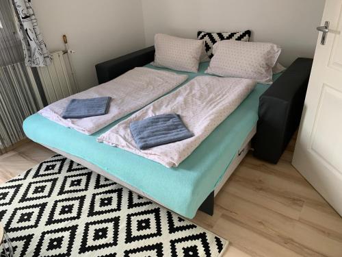 a bed with two pillows on it in a room at Rita Apartmanház in Bük