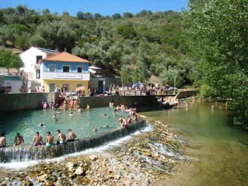 a group of people swimming in a river at Quinta Da Silva in Vale dos Ovos