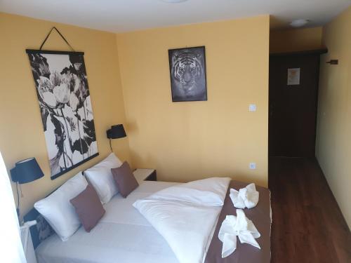 1 dormitorio con cama blanca y almohadas blancas en Anda vendégház, en Harkány