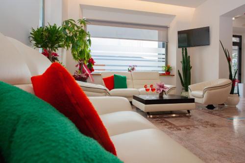 a living room with a white couch and red pillows at Hotel Giardino in Bibbiena