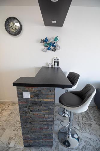 un bar avec un comptoir noir et un tabouret dans l'établissement STUDIO PROMENADE FLORIDA BEACH, à Nice