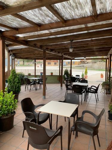 un patio al aire libre con mesas, sillas, mesas y sillas en La Laguna, en Uña