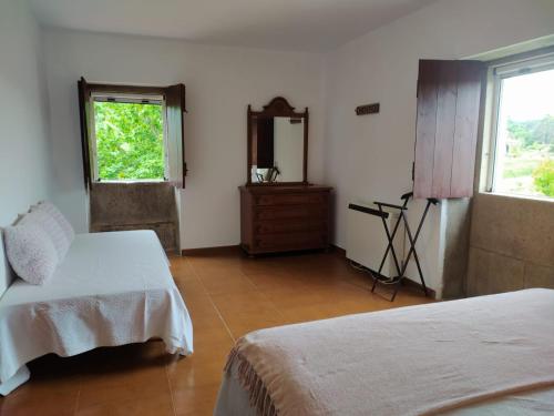 a bedroom with two beds and a mirror and a window at Casa Piñeirós in Asados