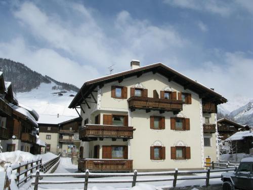 un bâtiment dans la neige avec une clôture autour dans l'établissement Residence L'Arcobi, à Livigno