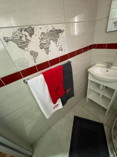 a bathroom with a red and white towel and a sink at Ithonsi Guesthouse in Kempton Park