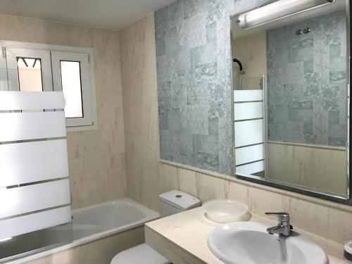 a bathroom with a sink and a toilet and a mirror at MI CAPRICHO 9B BEACHFRONT- Apartment with sea view - Costa del Sol in Mijas Costa