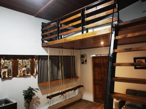 Cama elevada en habitación con ventana en Cabaña Hamacas, en Cartago