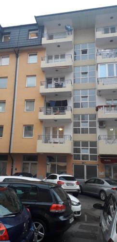 a parking lot with cars parked in front of a building at Apartman FAMILY in Foča