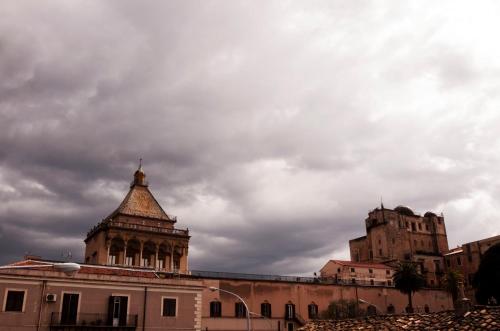 a building with a tower and a cloudy sky at La Piccola Formica Charme Rooms in Palermo