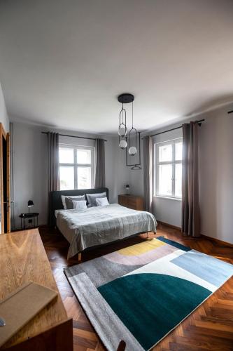 a bedroom with a bed and a rug on the floor at Villa Stara Apteka in Srebrna Góra