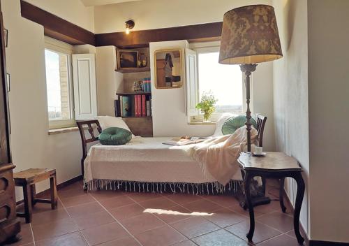 サン・ベネデット・デル・トロントにあるSelvaGiurata farmhouse villaのベッドルーム1室(ベッド1台、ランプ付きテーブル付)