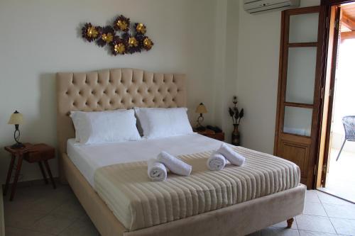 a bedroom with a large bed with towels on it at Sofotel in Koroni