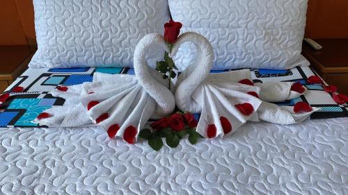 two swans towels on a white bed with roses at ATENEA SPA Hotel in Villeta