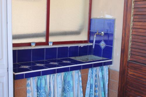a blue tiled counter in a room with a window at CasaLella in Letojanni