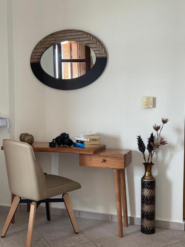 a desk with a chair and a mirror on a wall at Sofotel in Koroni