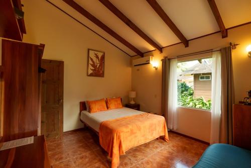 a bedroom with a bed and a window at Hotel Eco Arenal in Fortuna
