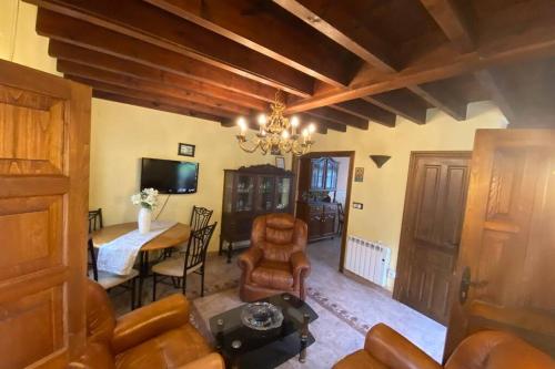 a living room with a chandelier and a table and chairs at Casa Triana, lugar idóneo para 4 o 6 huéspedes. in Infiesto