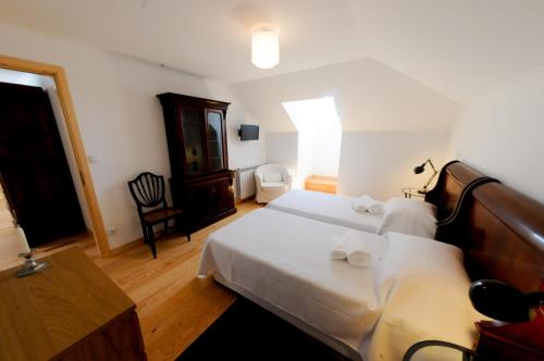 a bedroom with a bed with two white towels at Casa das Rendufas- Turismo Rural com Figos in Rendufas da Estrada