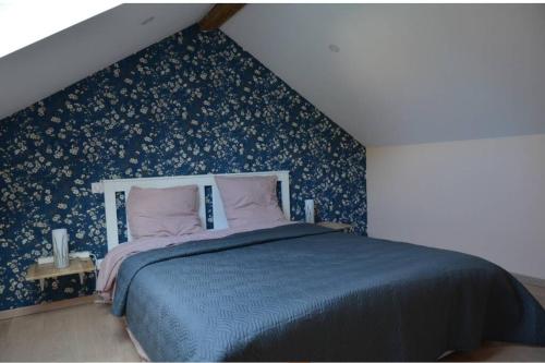 a bedroom with a blue bed with a blue wall at Jolie maison de centre-ville: Le Tournesac in Héricourt