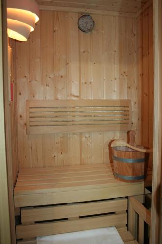 a sauna with a bench and a clock on the wall at Apartman Arena in Štrigova