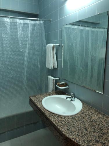 La salle de bains est pourvue d'un lavabo et d'une douche. dans l'établissement HOTEL CRUZ DA MATA, à Mangualde