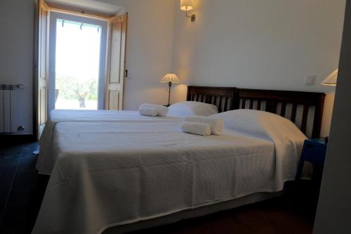 a bedroom with two beds with white sheets and a window at Casa das Rendufas- Turismo Rural com Figos in Rendufas da Estrada