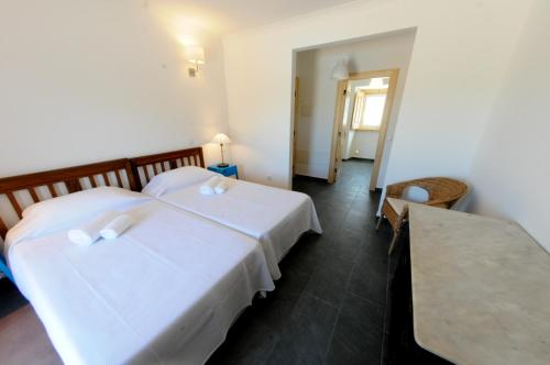 a hotel room with two beds and a table at Casa das Rendufas- Turismo Rural com Figos in Rendufas da Estrada