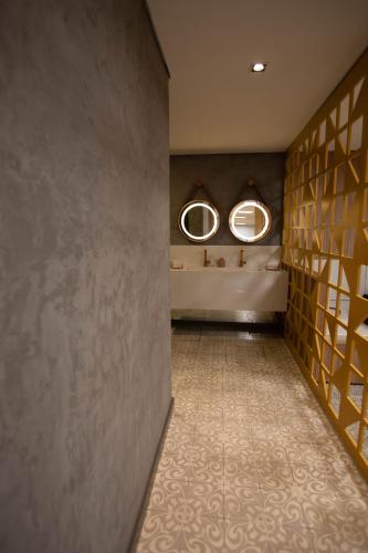 a hallway with two mirrors in a room with a wall at Summit Hotel Monaco in Guarulhos