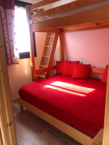 1 dormitorio con cama roja y escalera en Appartement Villard de Lans en Villard-de-Lans