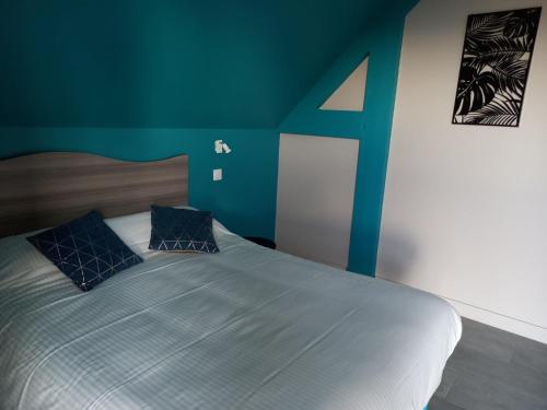 a bedroom with a large bed with blue walls at Les Lys in Cricquebœuf
