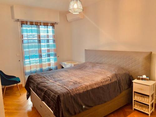 Un dormitorio con una cama grande y una ventana en City center cute flat with sea view one bedroom, en Niza