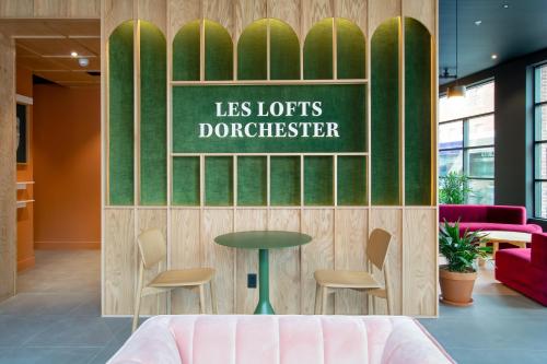 a waiting area with a table and chairs in a lobby at Les Lofts Dorchester - Par Les Lofts Vieux-Québec in Quebec City