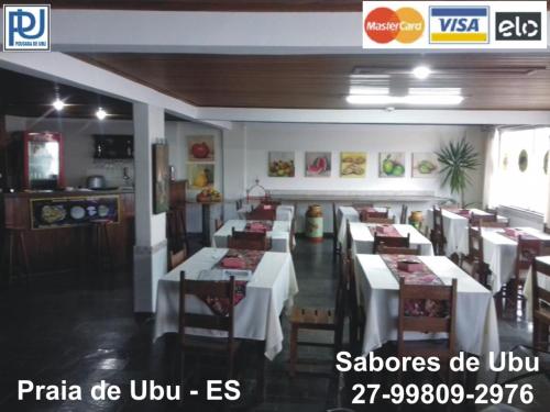a restaurant with tables and chairs in a room at Pousada de Ubu in Anchieta