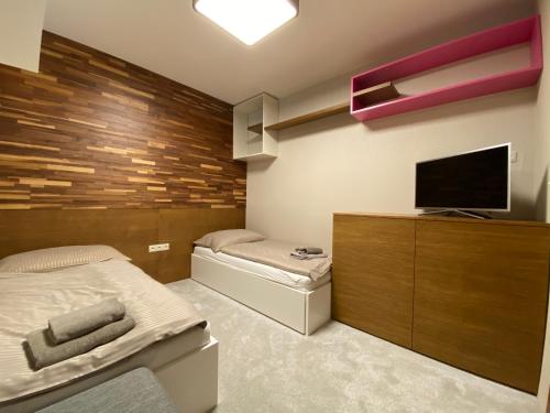 a bedroom with a bed and a flat screen tv at Apartman Romantika 13 Chopok juh Tale in Tale