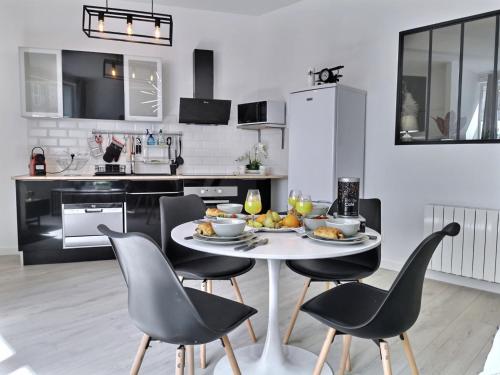 une cuisine avec une table et des chaises avec de la nourriture. dans l'établissement L'ATELIER - 500m Musée BD, à Angoulême