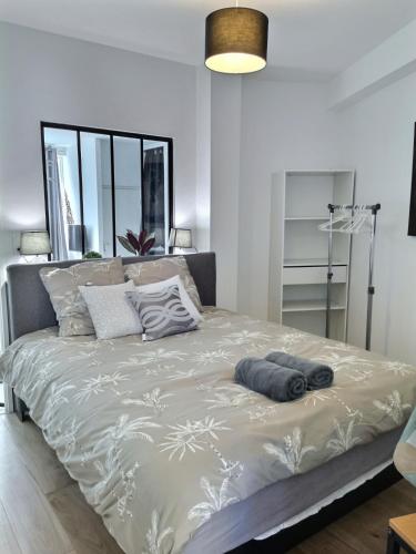 une chambre avec un grand lit avec des oreillers dessus dans l'établissement L'ATELIER - 500m Musée BD, à Angoulême