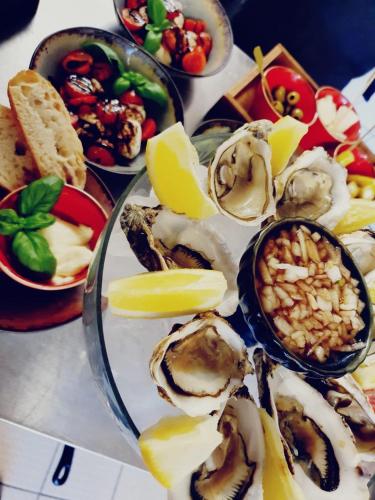 a table topped with plates of oysters and other foods at Hotel Rehkitz in Halle Westfalen